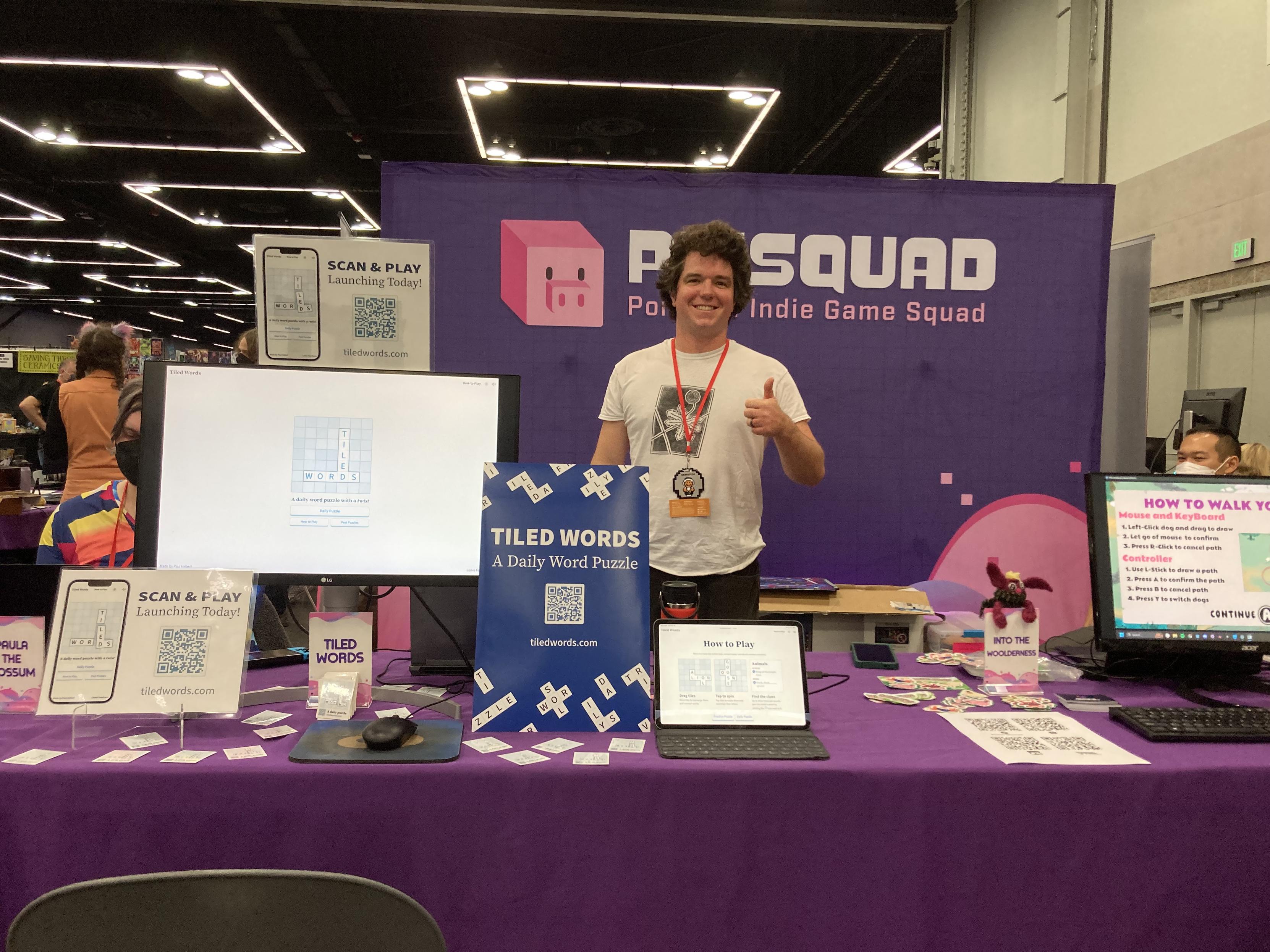 Me at a convention table with poster and devices